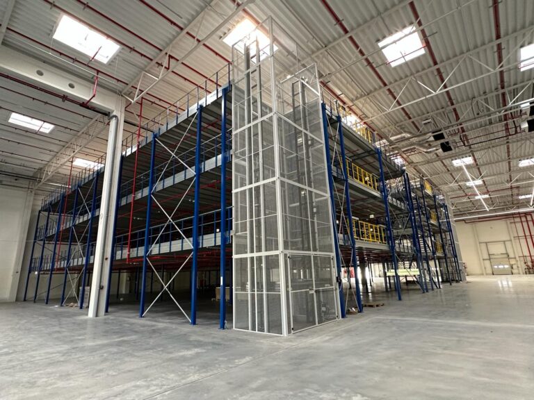 Mezzanine vloer op maat met stalen constructie en liftkooi in ruim magazijn