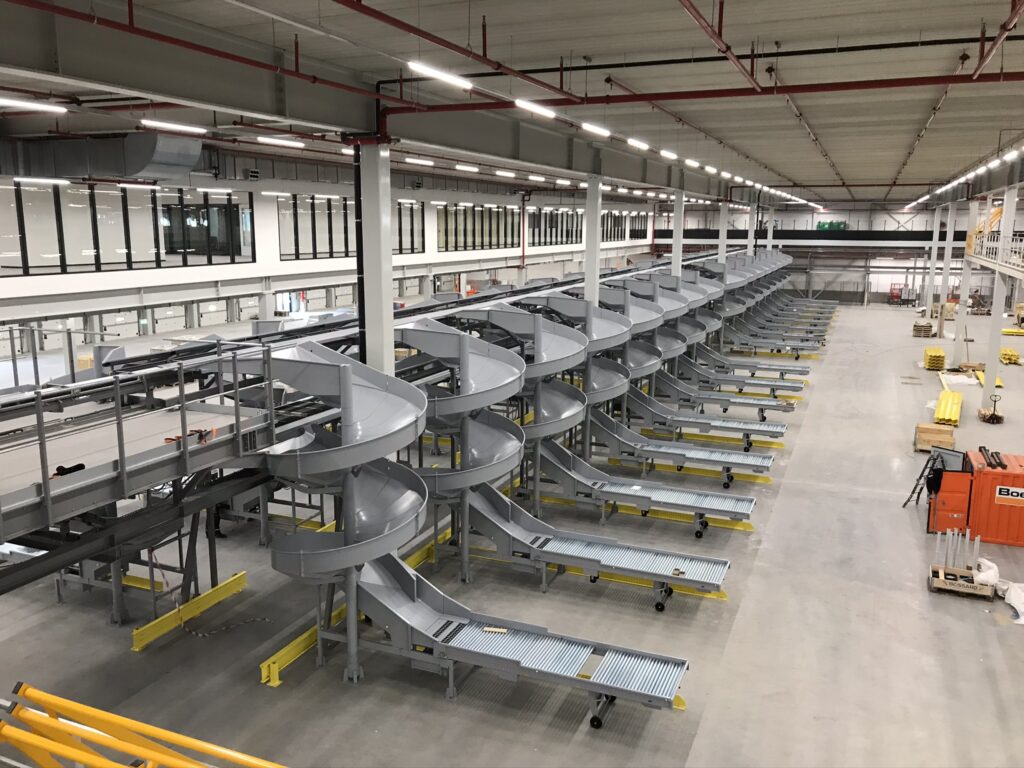 Mezzanine vloer met stalen constructie, spiraalglijbanen en rolbanen, op maat voor magazijn