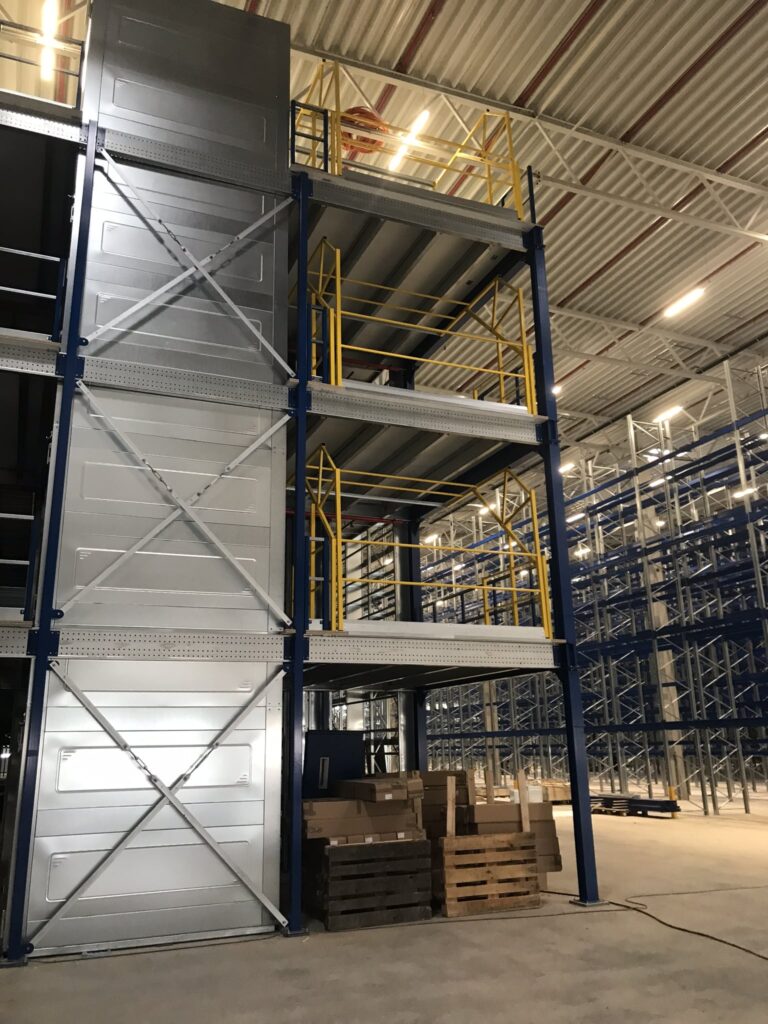Mezzanine vloer op maat met stalen kolommen vloerplaten en gele leuning in magazijn