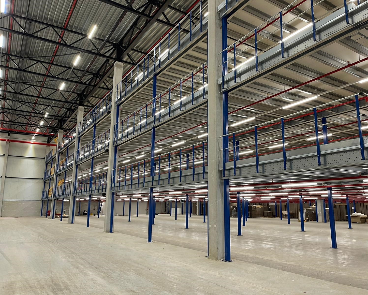 Mezzanine vloeren op maat met stalen constructie, leuningen en vloerplaten in magazijn
