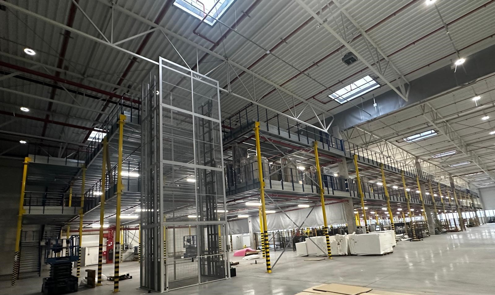 Entresolvloer op maat met stalen constructie, trap en leuning in groot magazijn